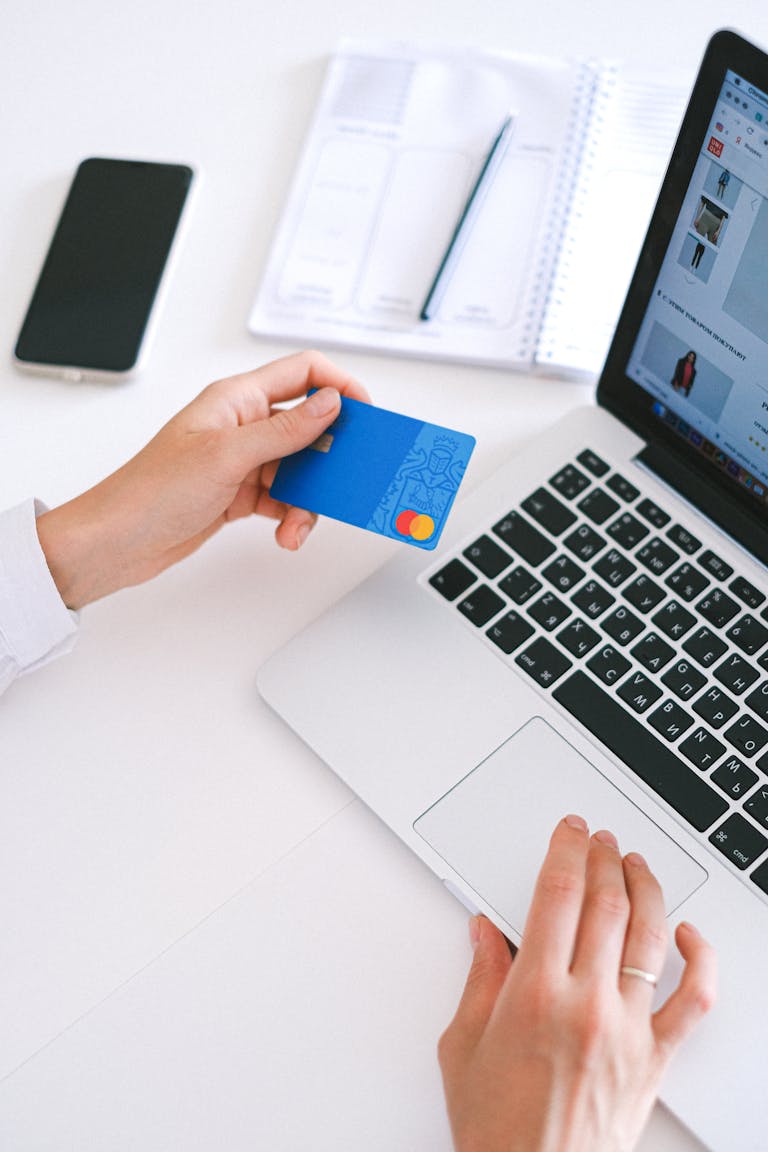 Person making an online purchase with a credit card on a laptop, to save miles and points for a trip.