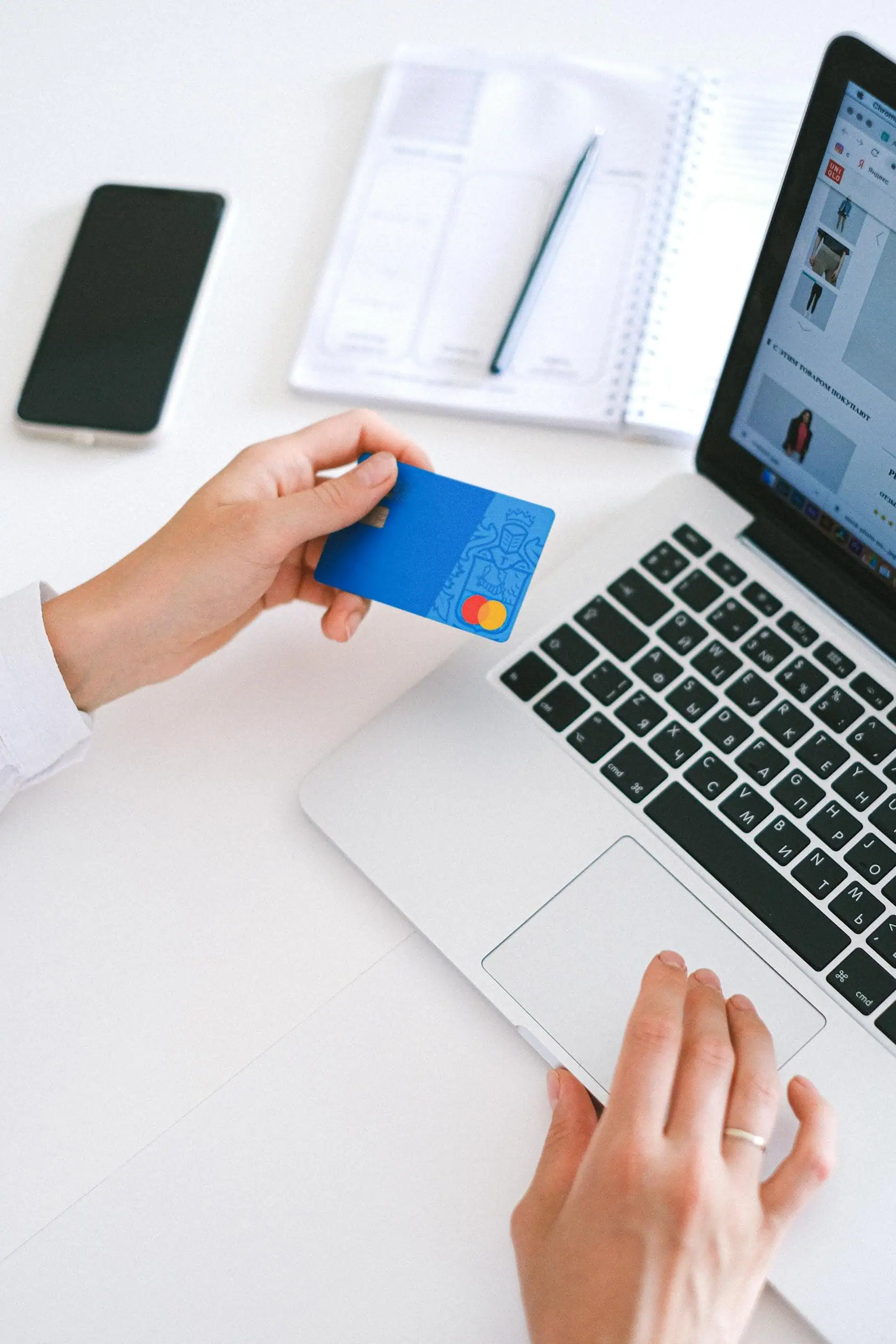 Person making an online purchase with a credit card on a laptop, to save miles and points for a trip.