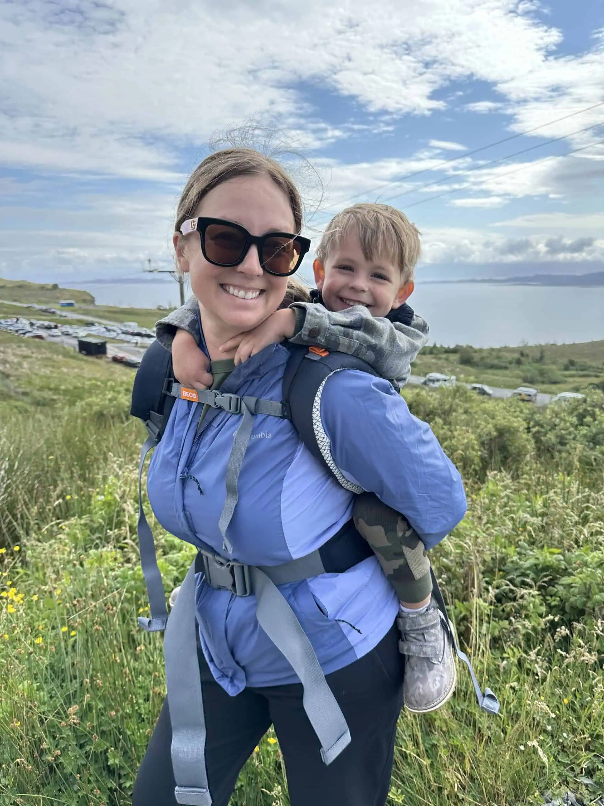 Mom hiking with a toddler on her back in Scotland