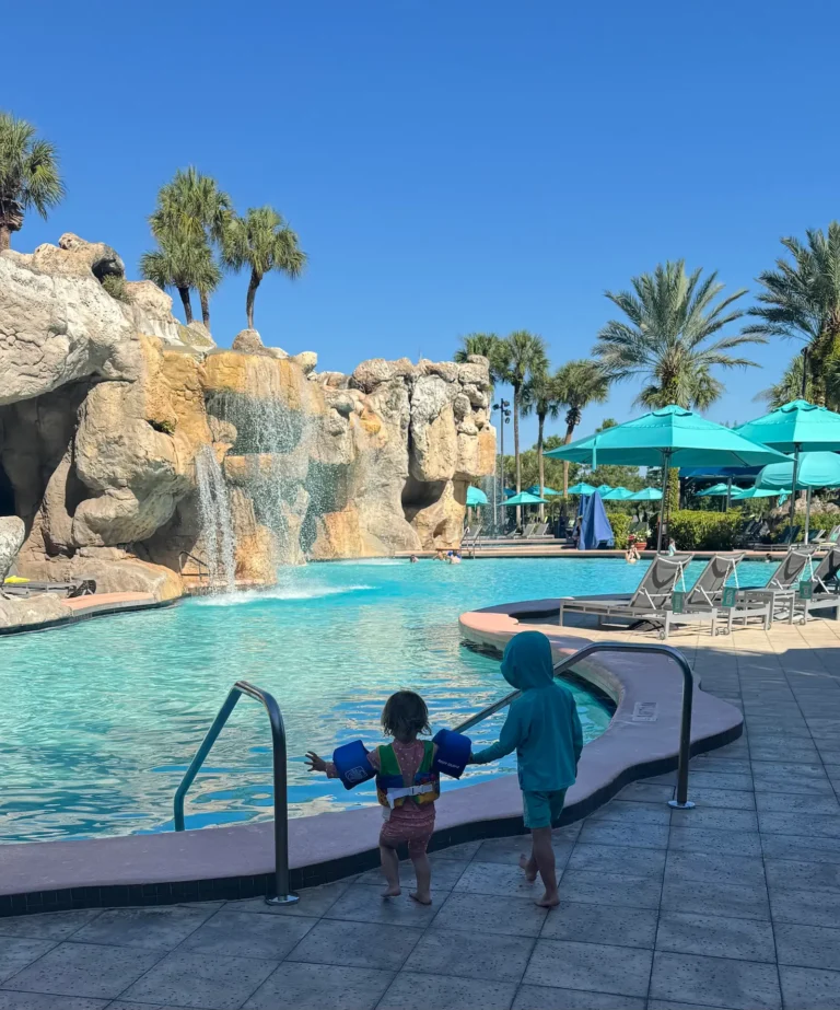 Toddlers walking toward pool with rock waterfall at Hyatt Regency Grand Cypress