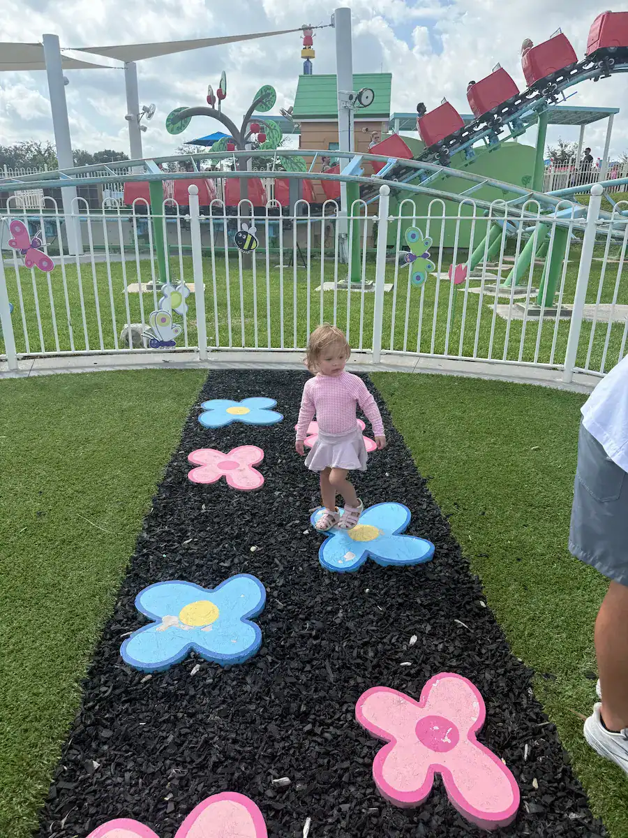 My daughter playing outside the roller coaster for Peppa Pig World