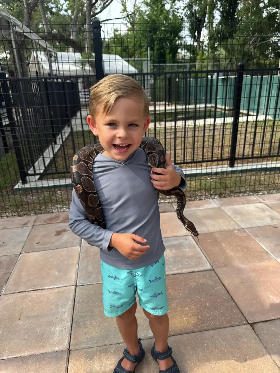 Toddler with snake around his neck