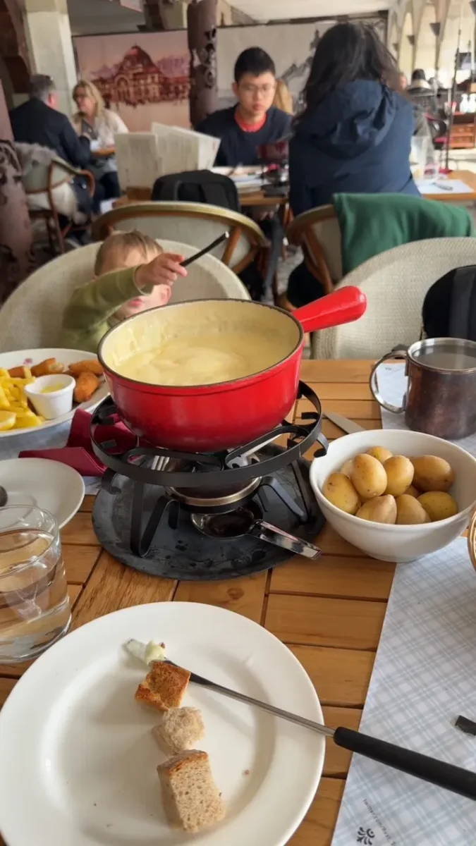 My son with his kids meal behind a giant pot of Fondue.